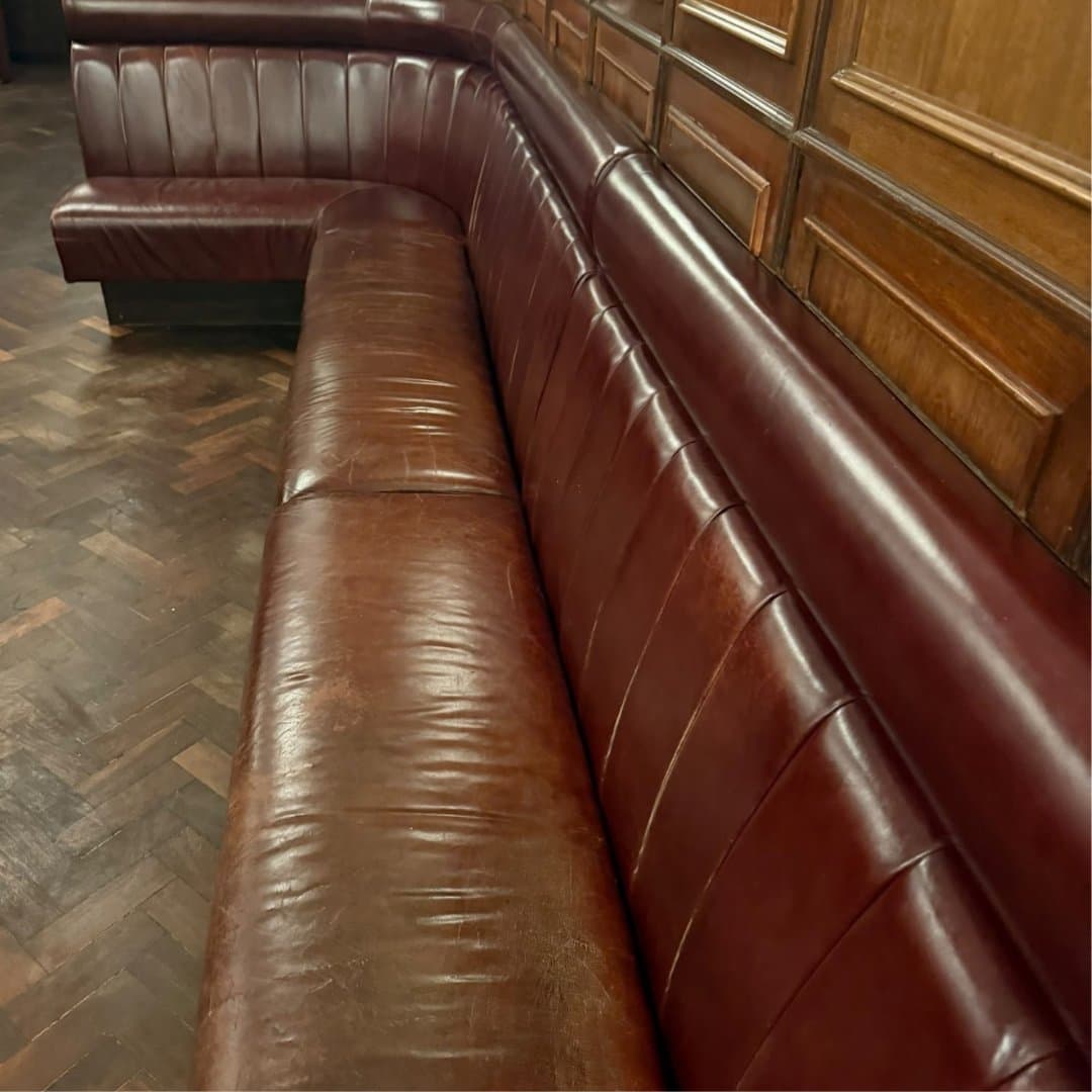 Worn leather banquette at Hawksmoor Guildhall before refurbishment