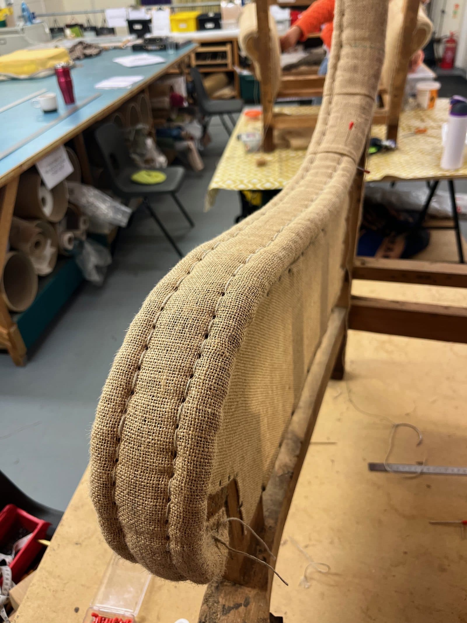 A top-stuffed arm re-formed in hessian and stitched before covering