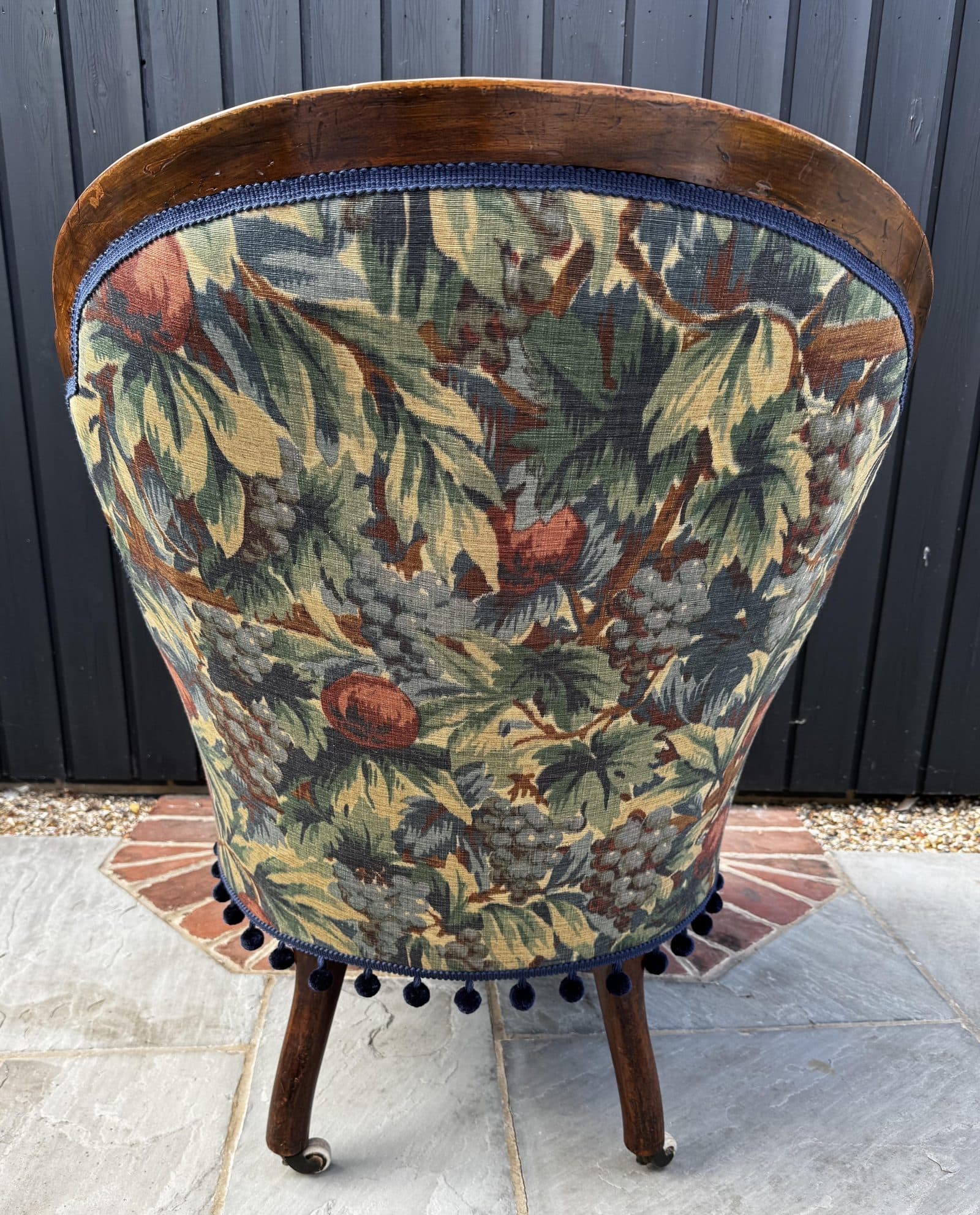 The outside back of Emma Wrafter's armchair, finished with pom-pom trim