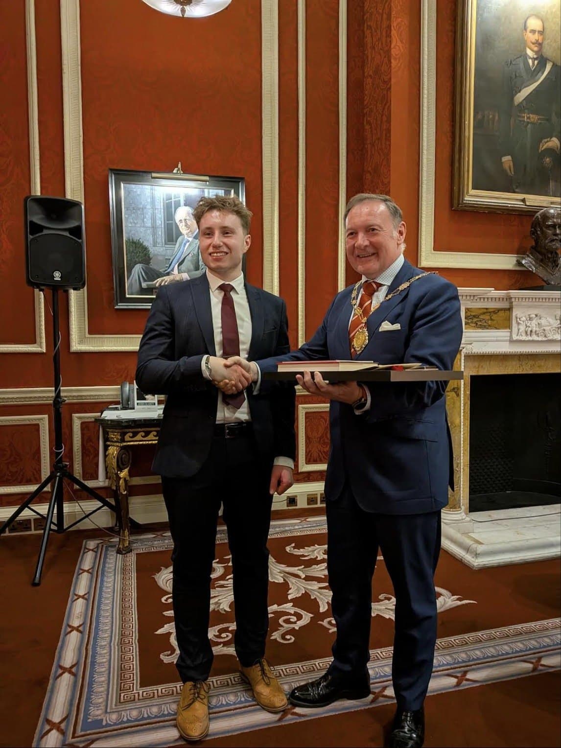Luke Newton receives his award from Master Joiner Jeremy Baldwin at the Royal Automobile Club