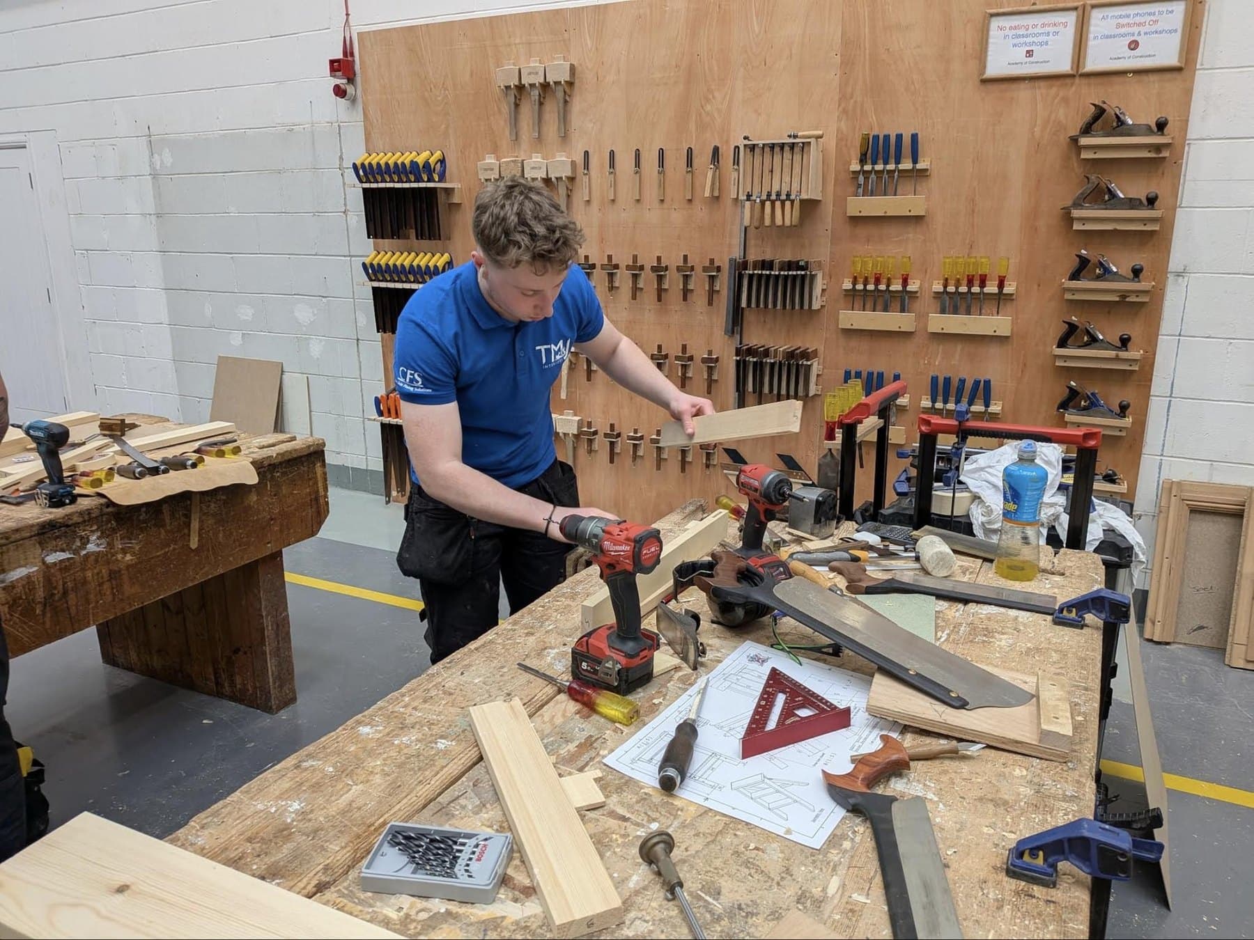 Luke Newton at the bench during the Craft Competition, checking a component against the drawing